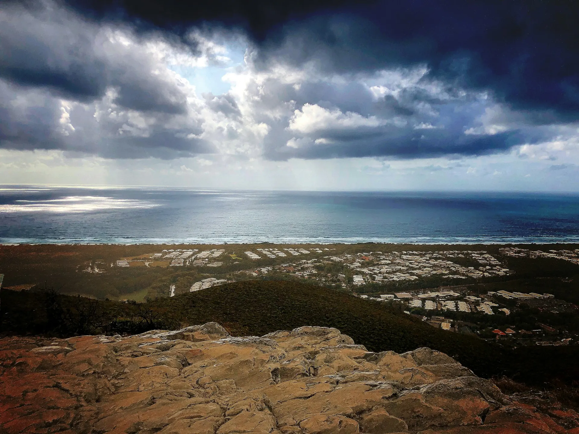 Coolum township and the coast seen from the summit of Mount Coolum under a storm sky